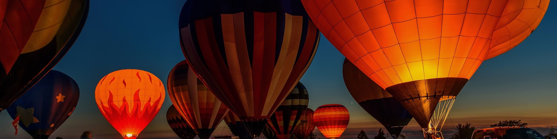 hot air balloons glowing in night sky