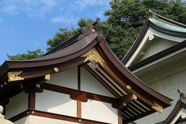 A traditional building with ornate wooden eaves and a green roof.