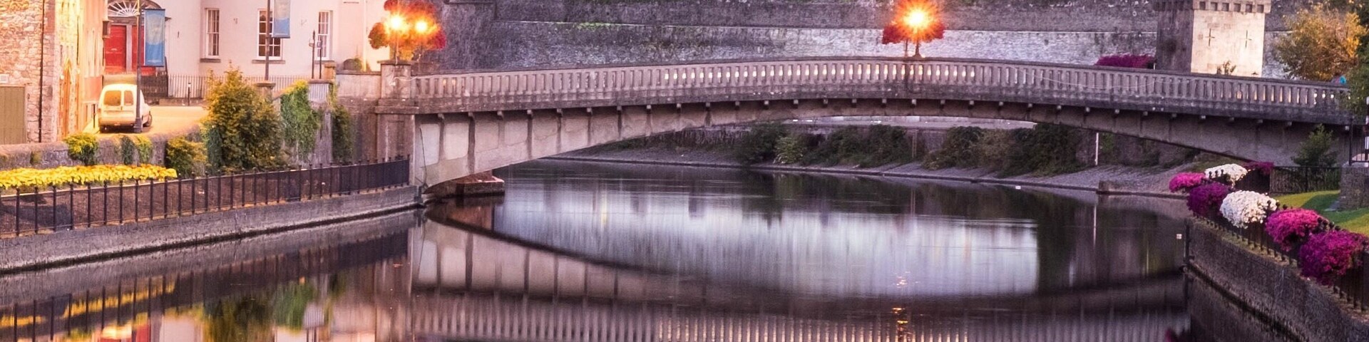 Un castillo, un puente y un río tranquilo que refleja los edificios.