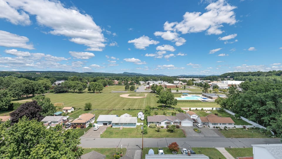 A suburban neighborhood with houses, a baseball field, and a swimming pool.