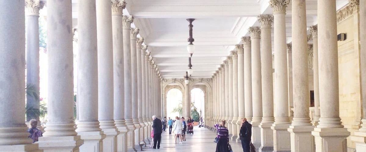 A grand corridor with tall columns and a high ceiling.