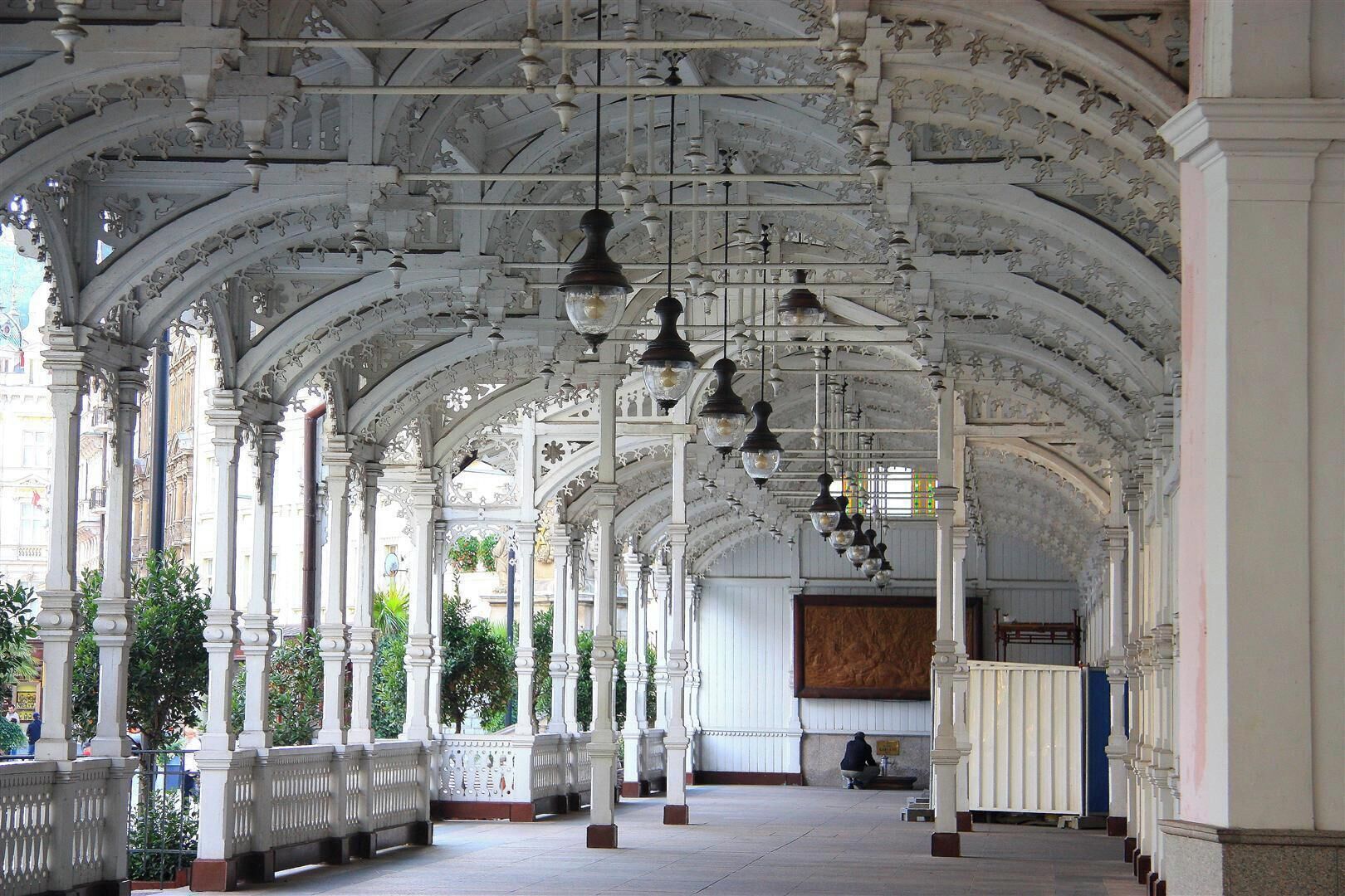 Market Colonnade (1883, Fellner & Helmer)

Karlovy Vary (Karlsbad,Carlsbad)
The wooden structure inspired by Swiss architecture was meant to arch over mineral springs for a couple of years only. However, when it surmounted the Market Spring and the Charles IV Spring (Tržní and Karla IV.) for more than a hundred years, the local authorities decided to keep it in place and ordered its overall reconstruction.

