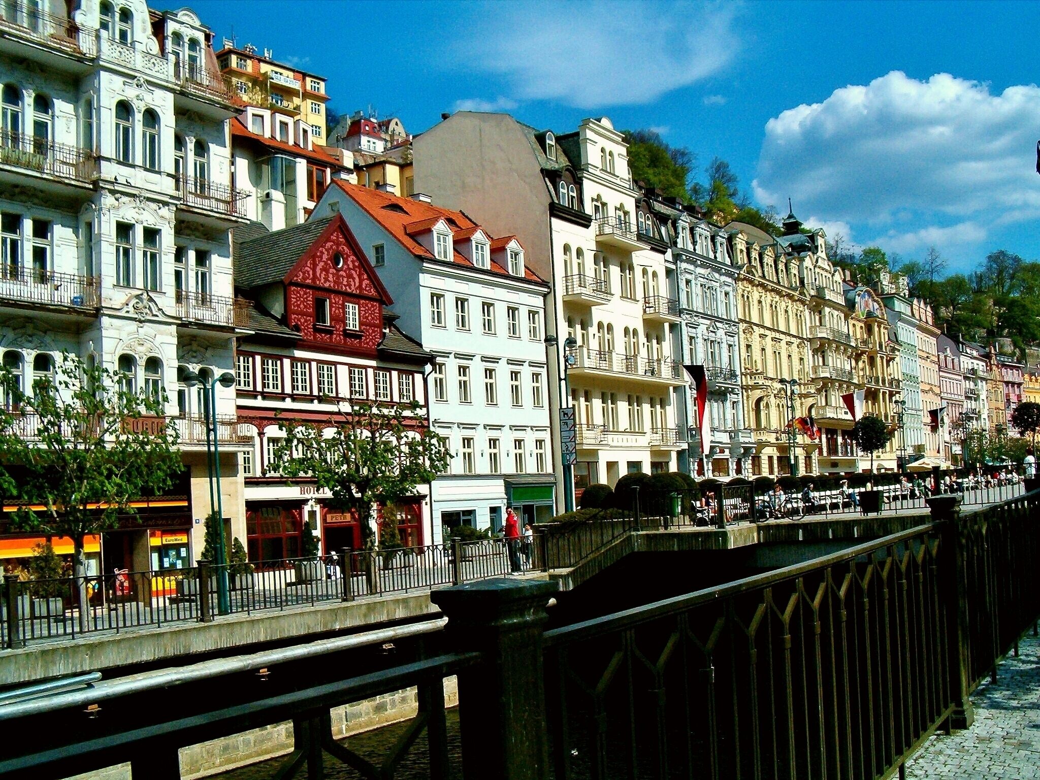 A row of colorful historic buildings along a river with a bridge in the foreground.