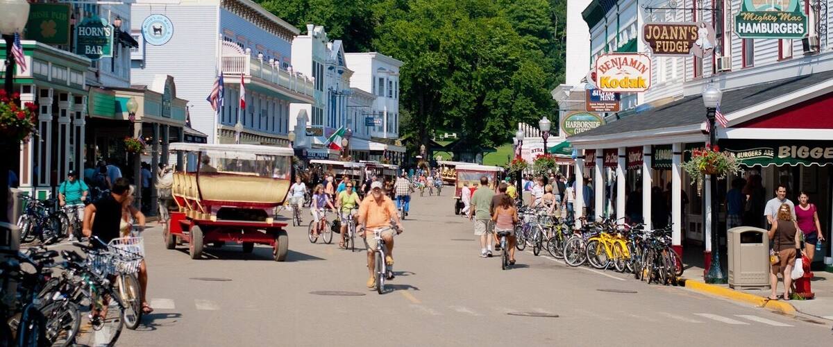 Una calle animada bordeada de tiendas, bicicletas y un tranvía antiguo.