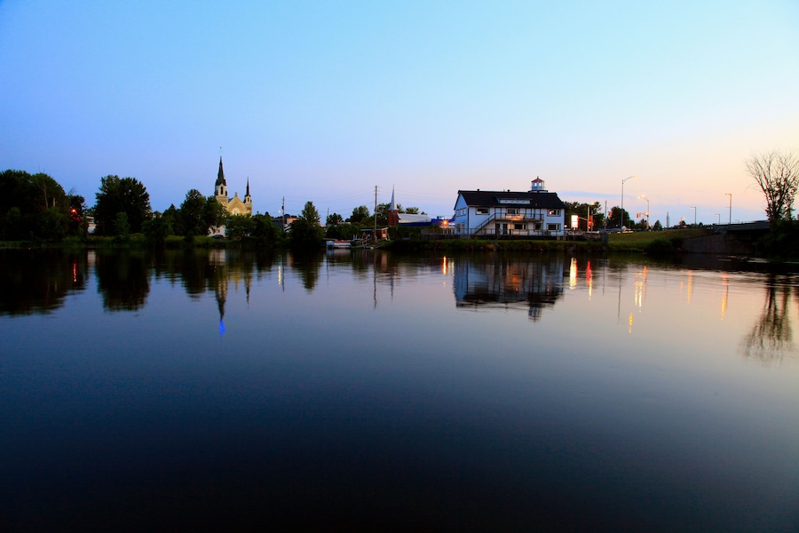 Un lago tranquilo con una iglesia y una casa reflejadas en el agua.
