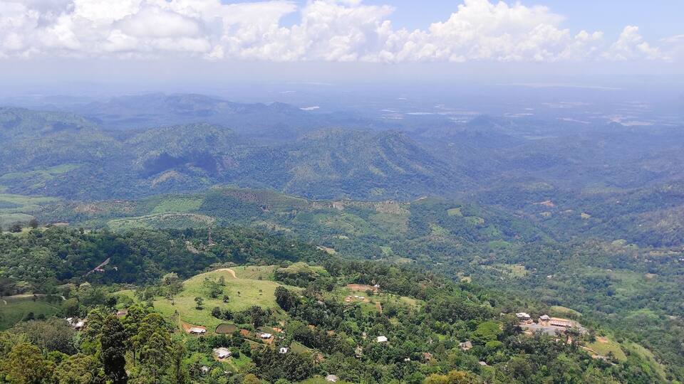 A mountainous landscape with scattered houses and greenery.