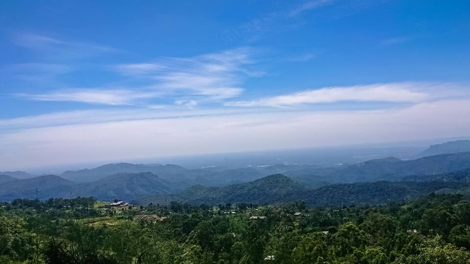 A mountainous landscape with rolling hills and scattered buildings.