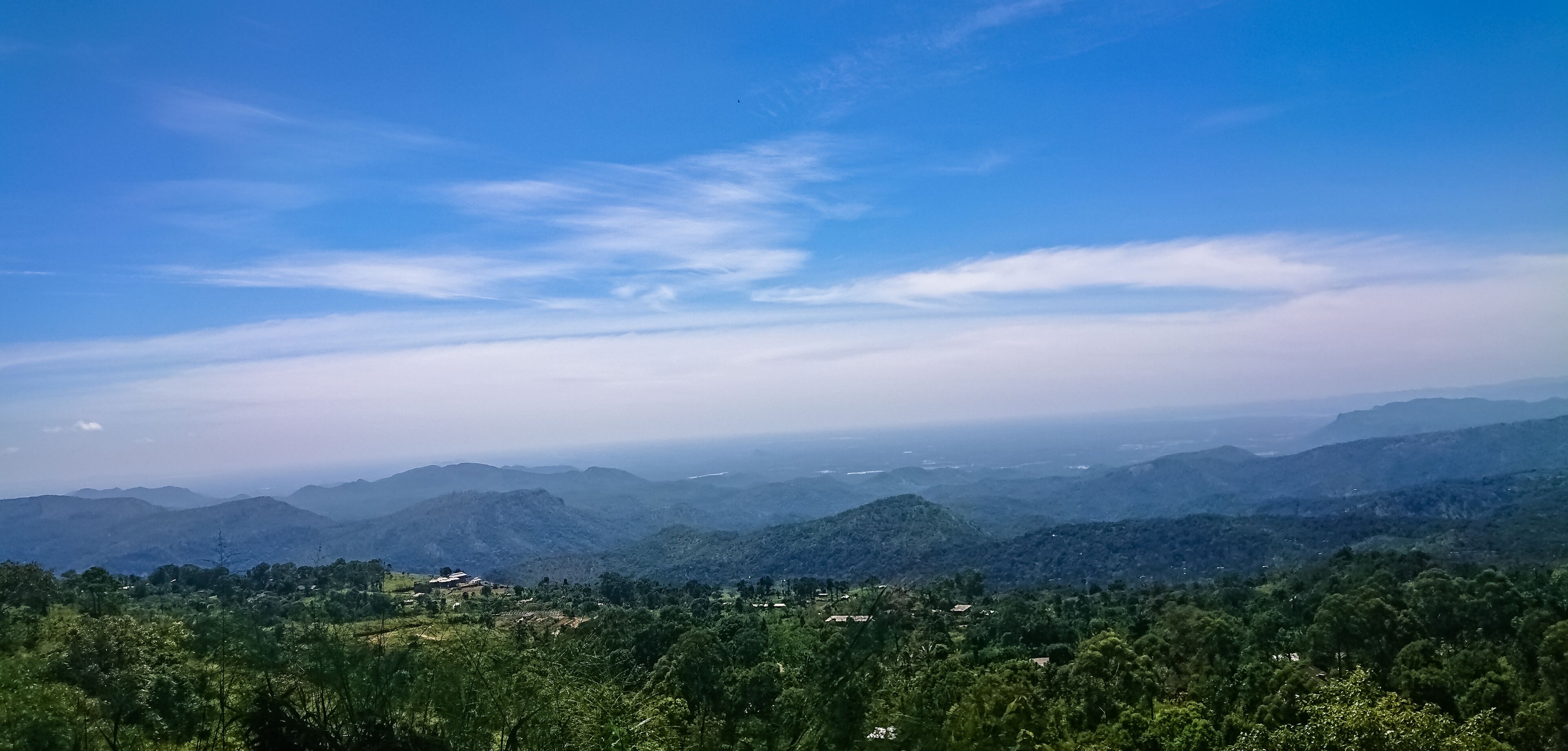 A mountainous landscape with rolling hills and scattered buildings.