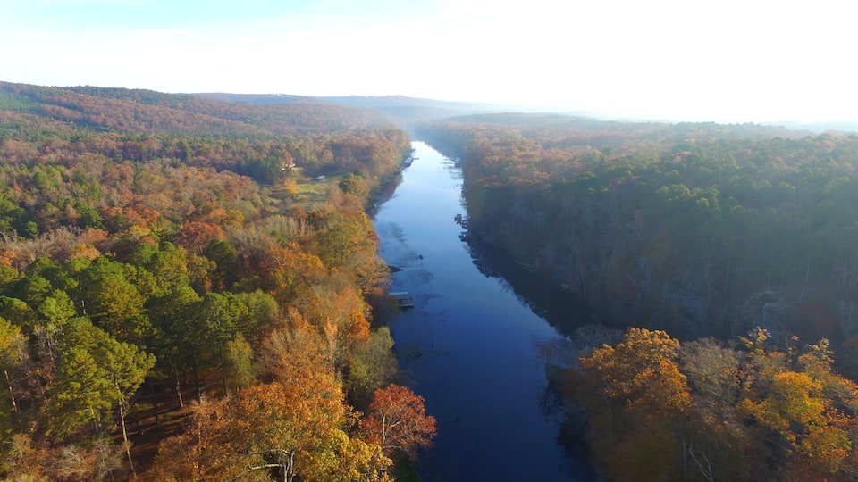 A river winding through a forest with autumn foliage.