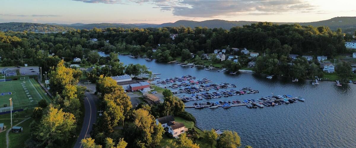 A lakeside community with a marina, houses, and a football field.