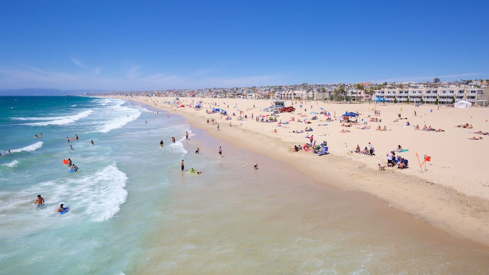 A crowded beach with people sunbathing and swimming.