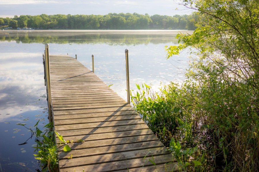 HWMWK0 A well lit dock just out onto a serene lake in Brooklyn, Michigan.
