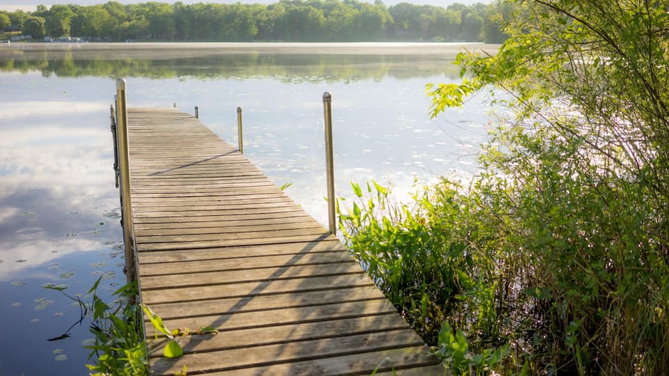 HWMWK0 A well lit dock just out onto a serene lake in Brooklyn, Michigan.