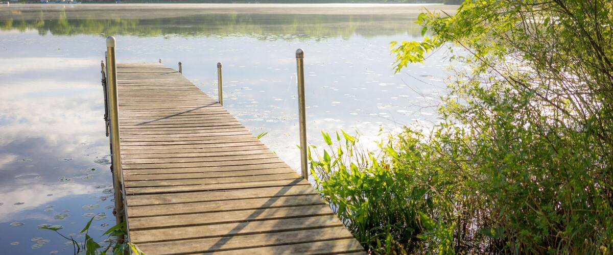 HWMWK0 A well lit dock just out onto a serene lake in Brooklyn, Michigan.