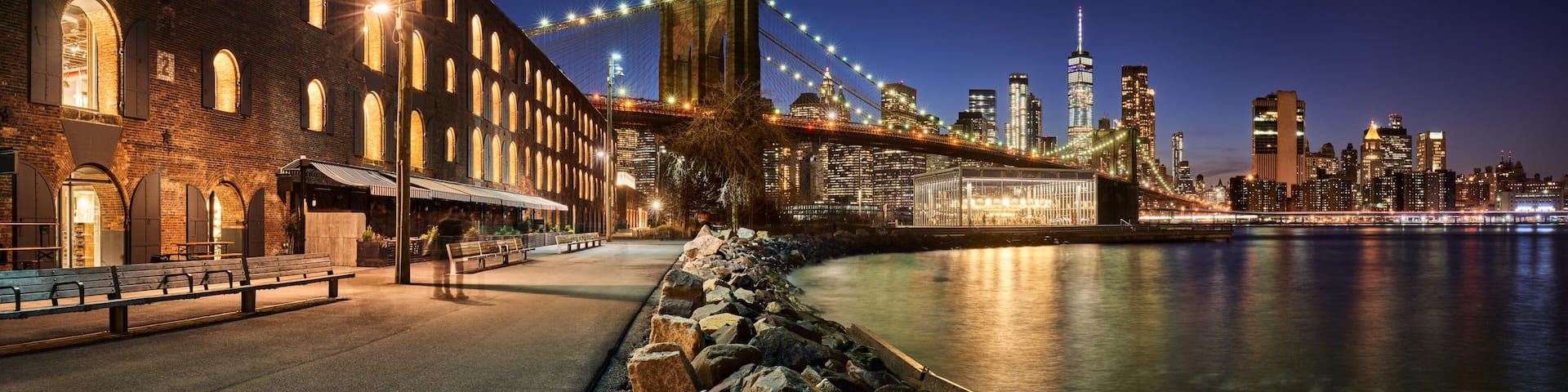 Brooklyn Bridge Park waterfront in evening with view of skyscrapers of Lower Manhattan and the Brooklyn Bridge. Brooklyn, Manhattan, New York City