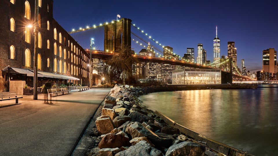 Brooklyn Bridge Park waterfront in evening with view of skyscrapers of Lower Manhattan and the Brooklyn Bridge. Brooklyn, Manhattan, New York City