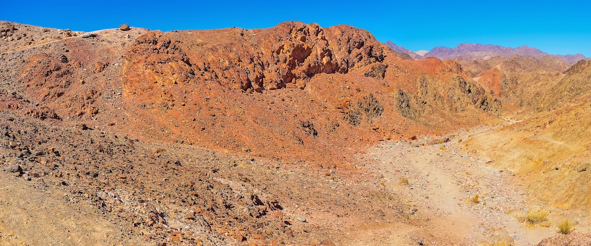 A rugged mountainous landscape with rocky terrain and a narrow valley.
