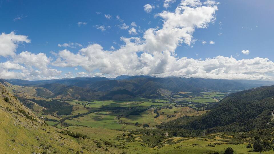 A valley with rolling hills and a winding road.