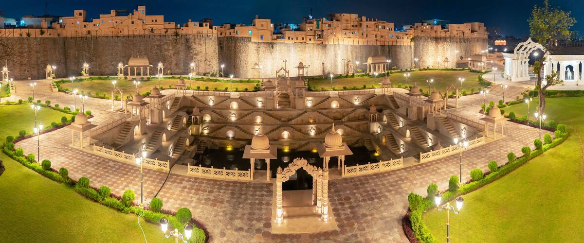 A historic fort with a central courtyard featuring ornate arches and a well-maintained garden.
