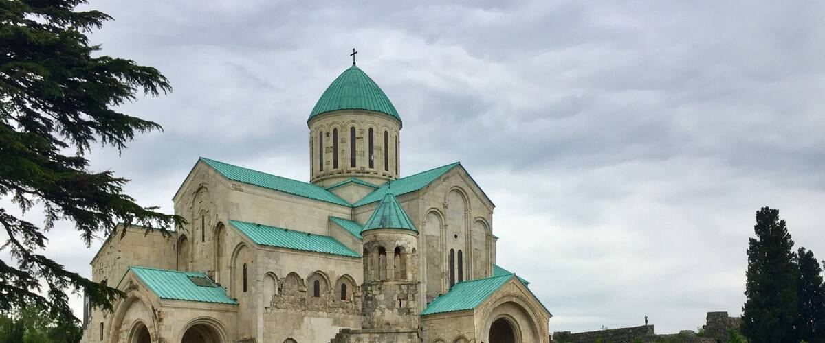 A historic church with a green dome and multiple arched windows.