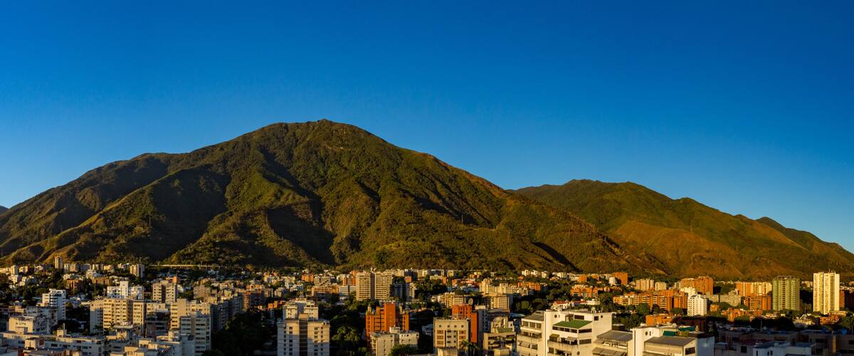 A cityscape with a prominent mountain in the background.
