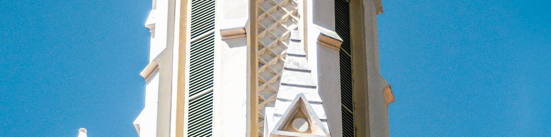 A church with a tall spire, intricate architectural details, and a clock.