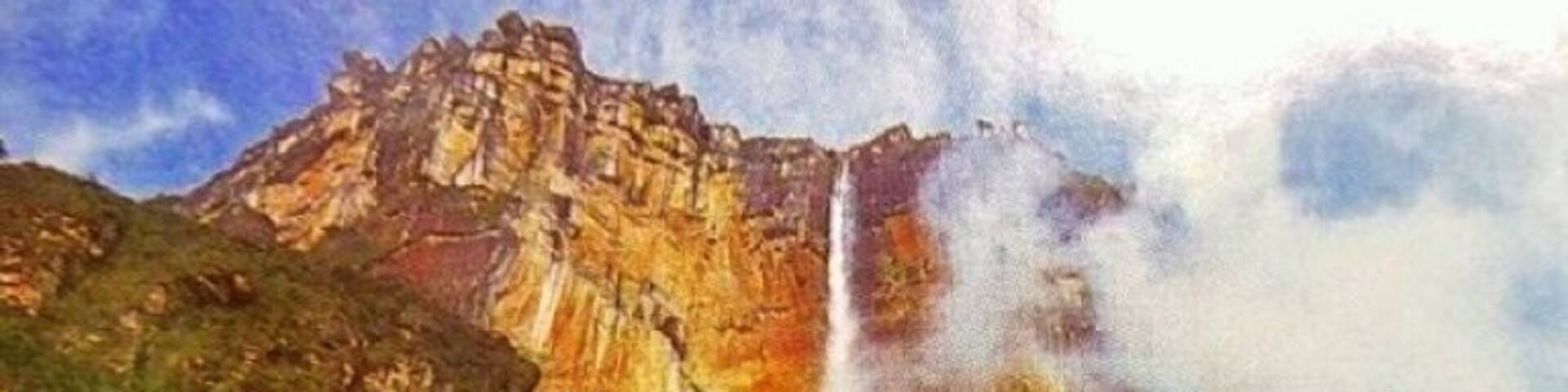 A waterfall cascading down a rocky cliff surrounded by greenery.