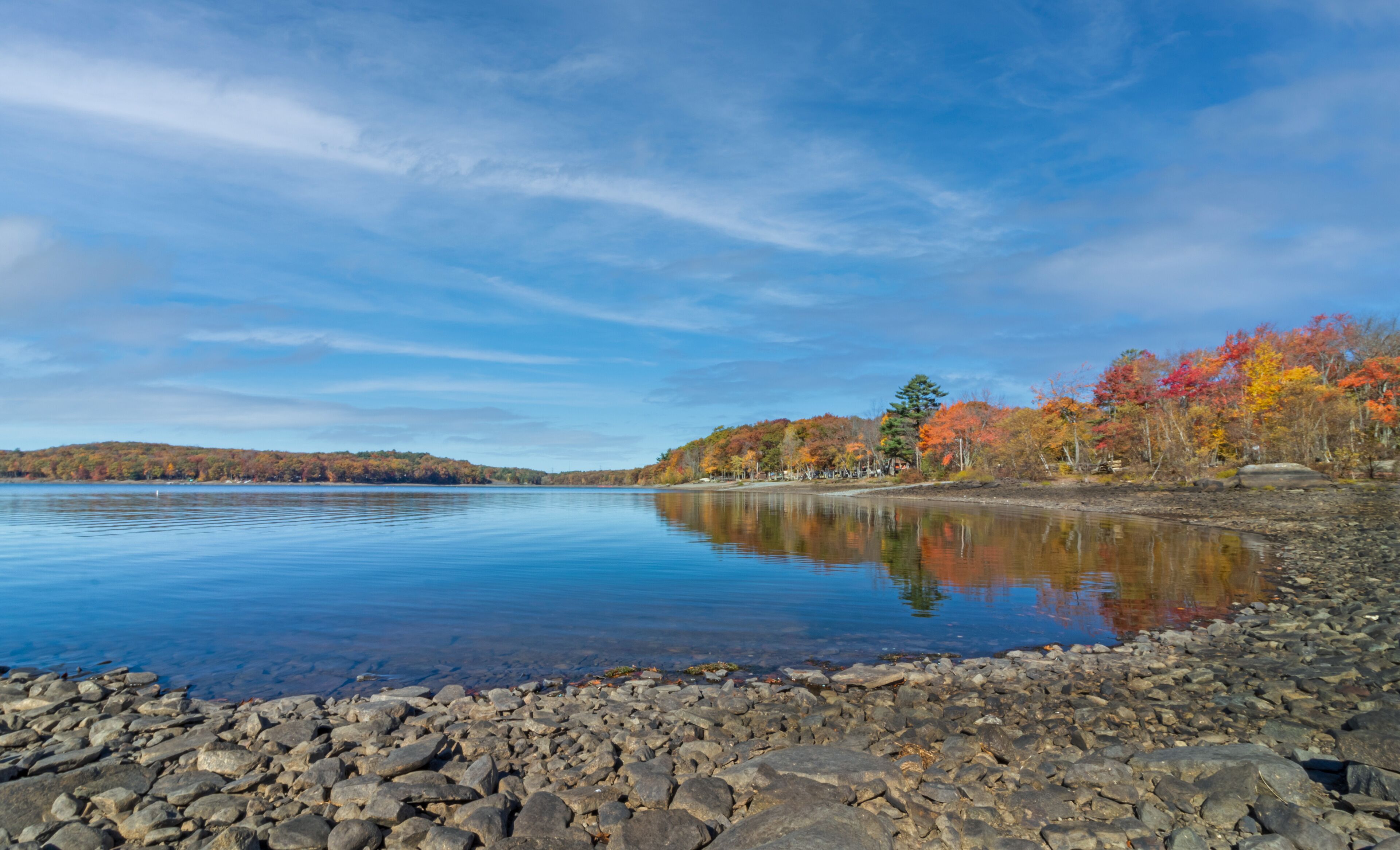 Lake Wallenpaupack in Poconos PA on a bright fall day lined with trees in vivid and beautiful foliage