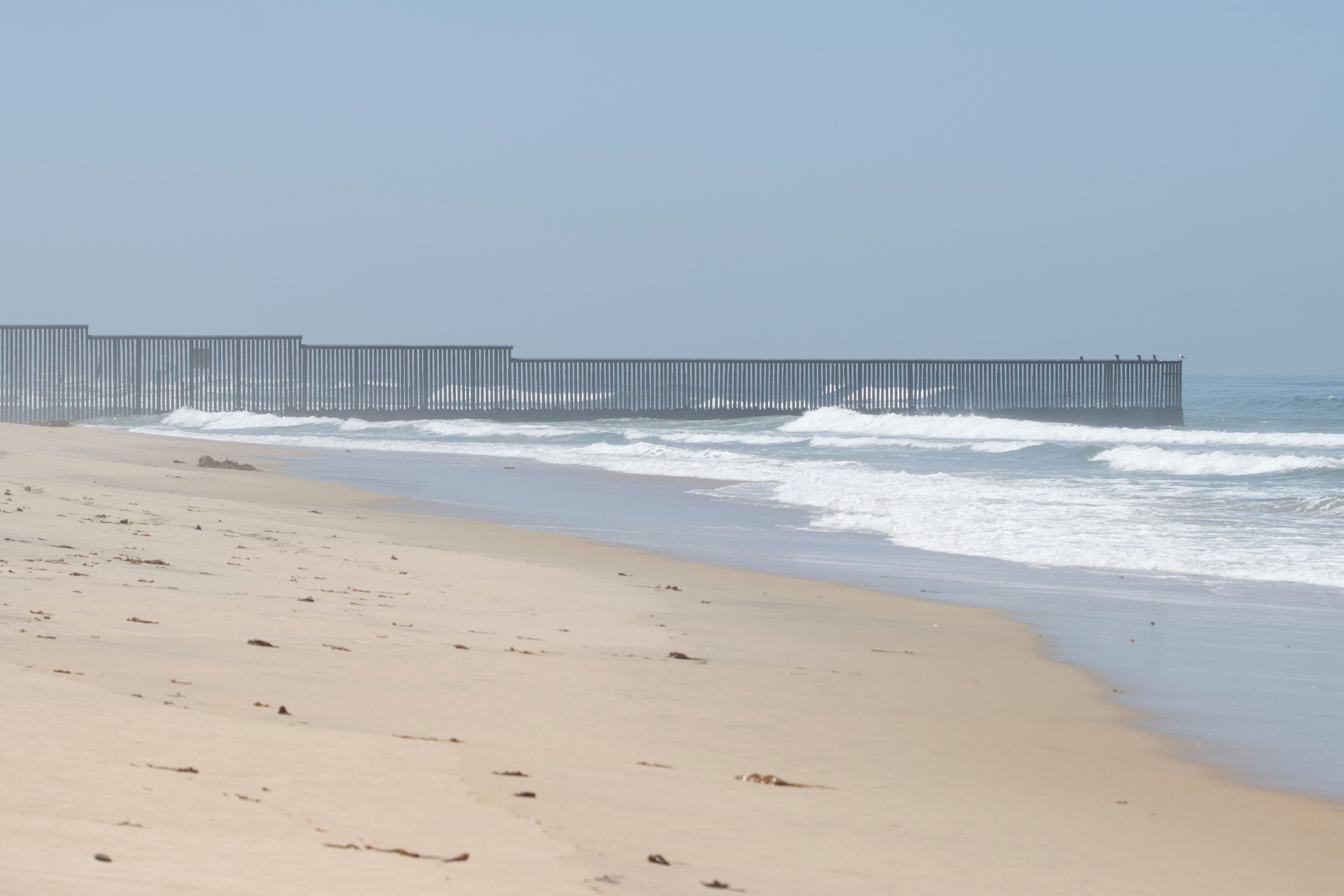 Vertical border fence between the U.S. and Mexico viewed from the beach at the Border Field State Park in San Diego, California. It separates San Diego from Tijuana and extends into the Pacific Ocean.