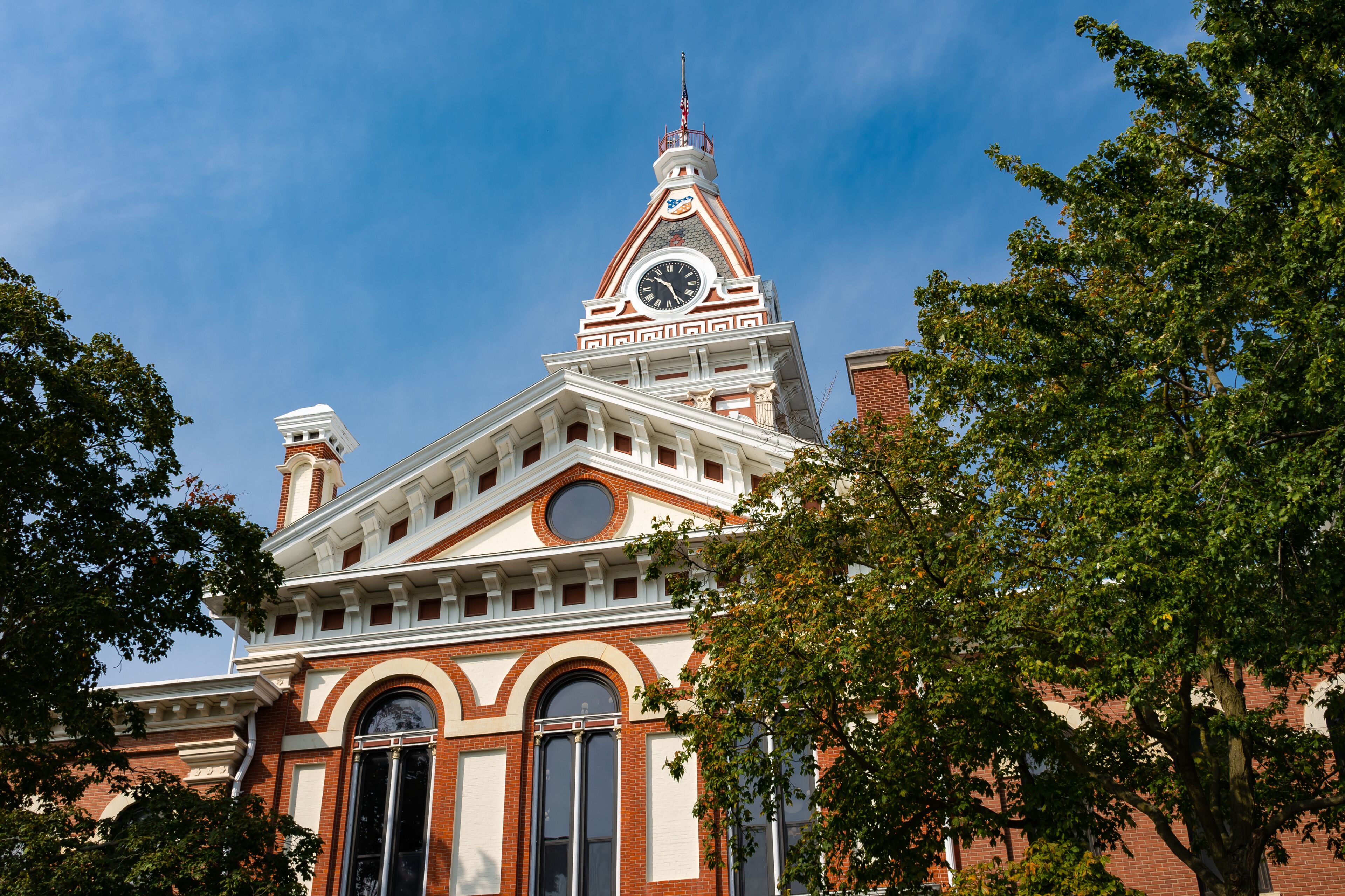 A historic building with a clock tower, arched windows, and a prominent chimney.