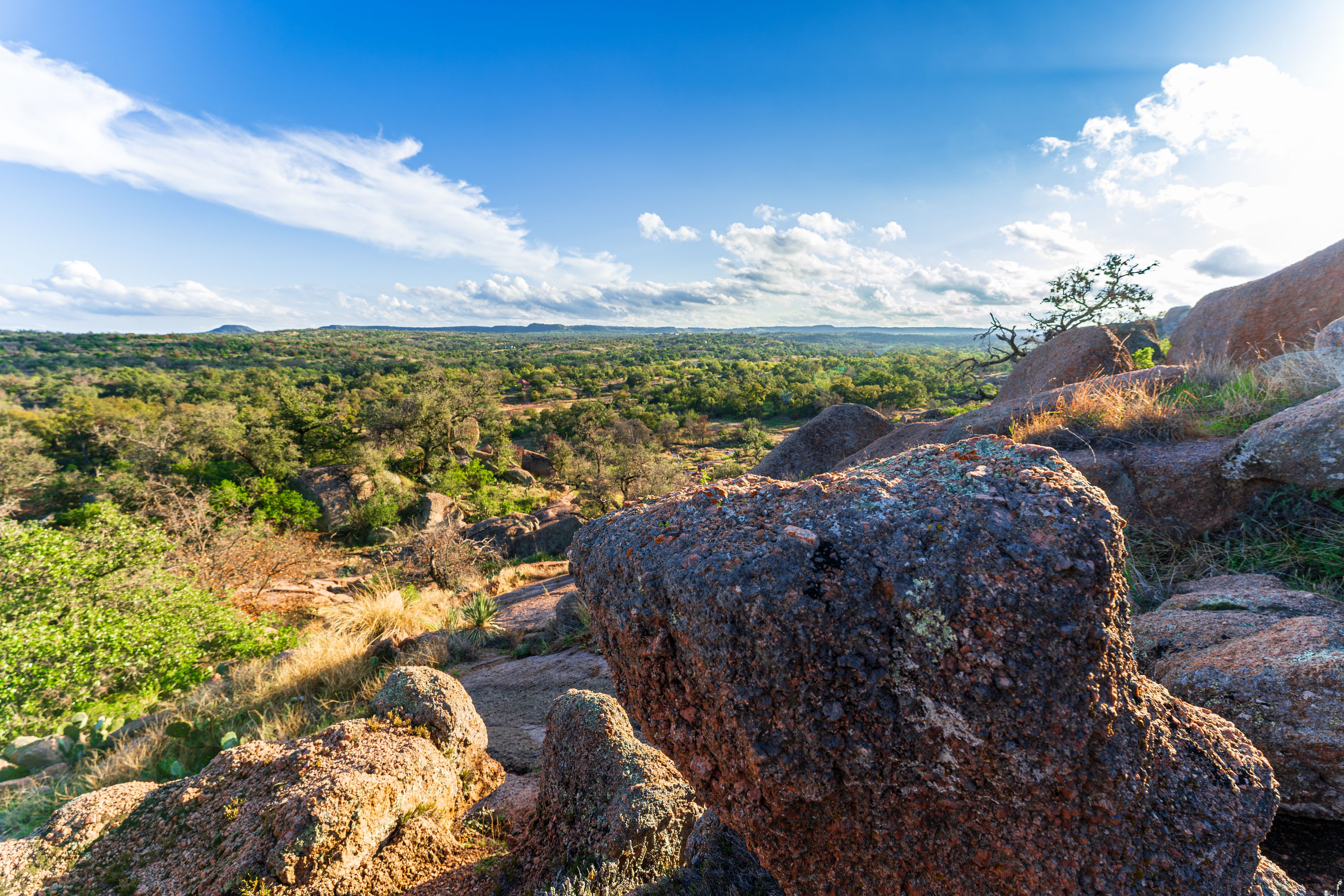 A rocky landscape with a clear sky and distant hills.