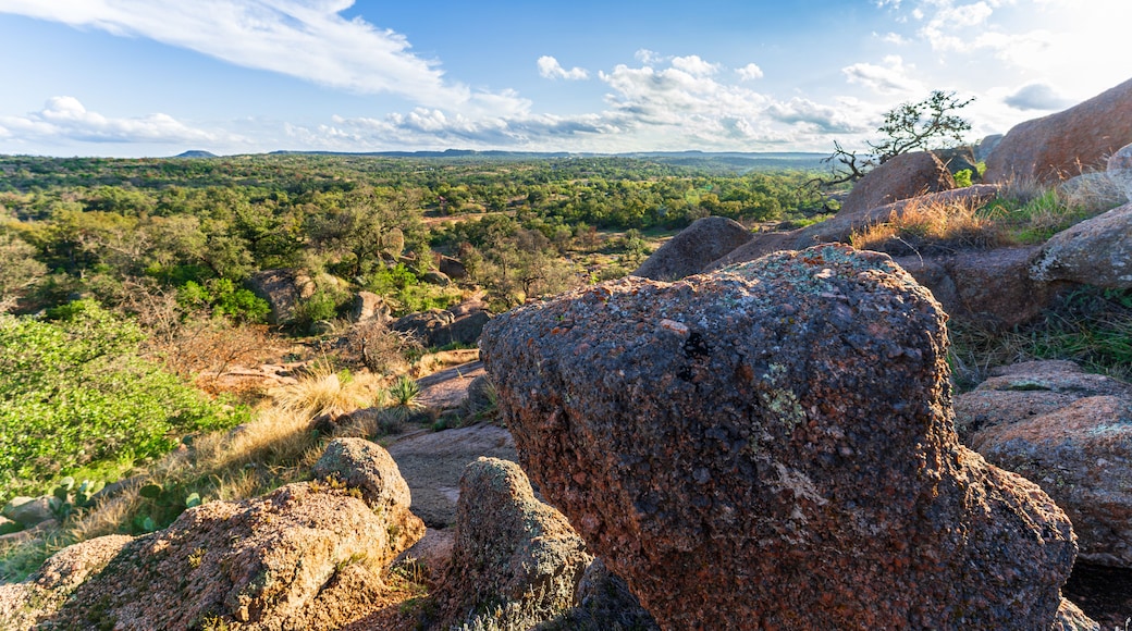 A rocky landscape with a clear sky and distant hills.