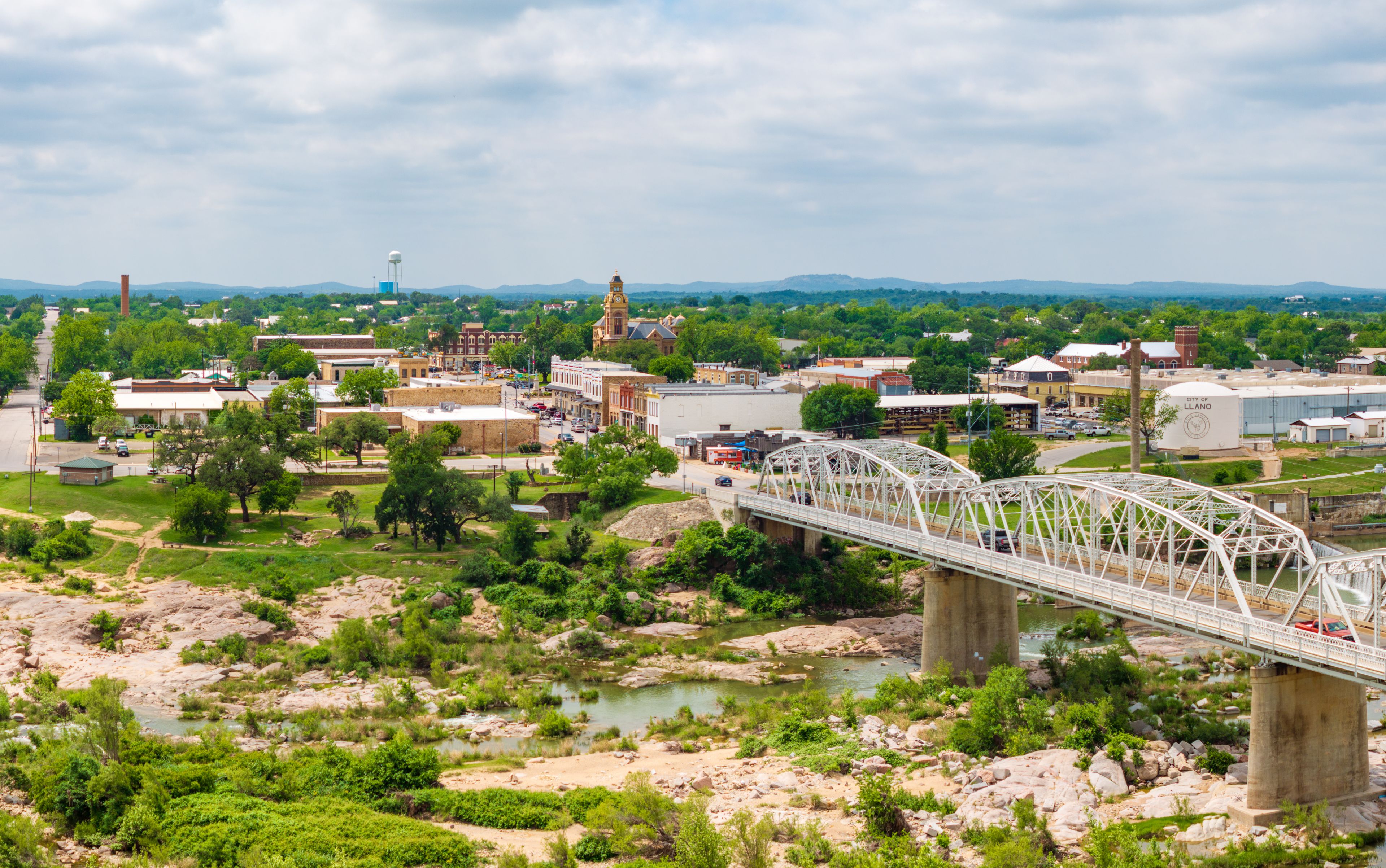 Aerial shot of Ford Street bridge and downtown Llano, Texas Hill Country. Drone point of view captures the panoramic scene