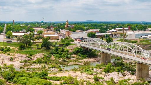 Aerial shot of Ford Street bridge and downtown Llano, Texas Hill Country. Drone point of view captures the panoramic scene