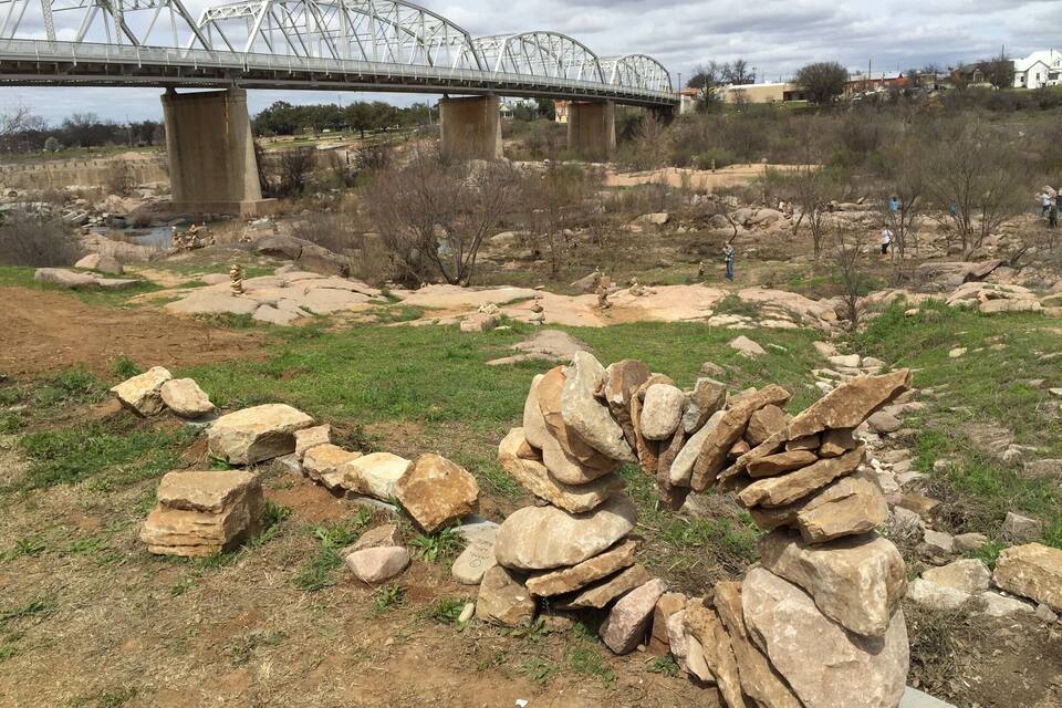 A bridge, rocky terrain, and sparse vegetation.