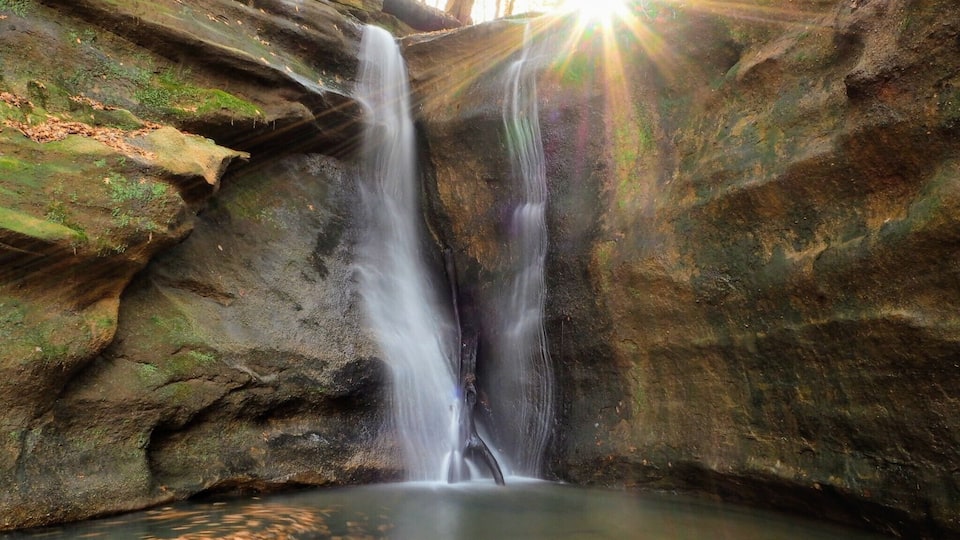 A waterfall cascading down a rocky cliff into a pool.