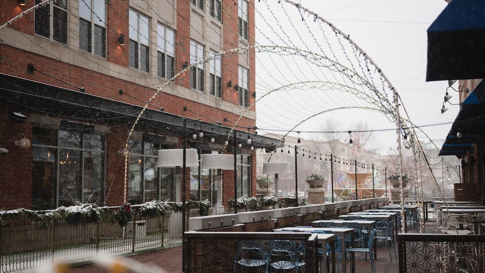 Snowy outdoor dining patio with decorative light arches in downtown Naperville, Illinois