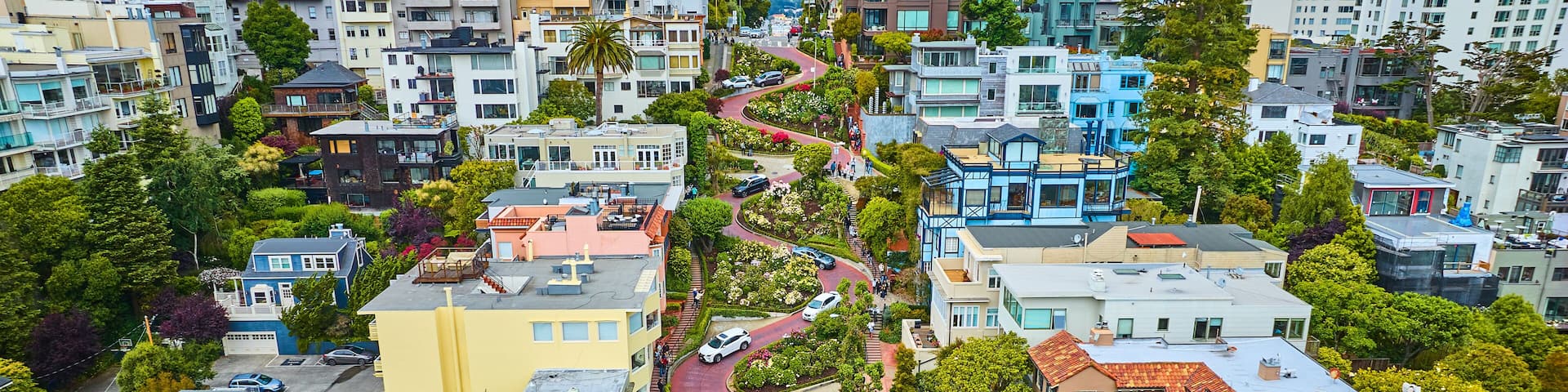 Gorgeous wider aerial of iconic Lombard Street with buildings on either side of red brick road
