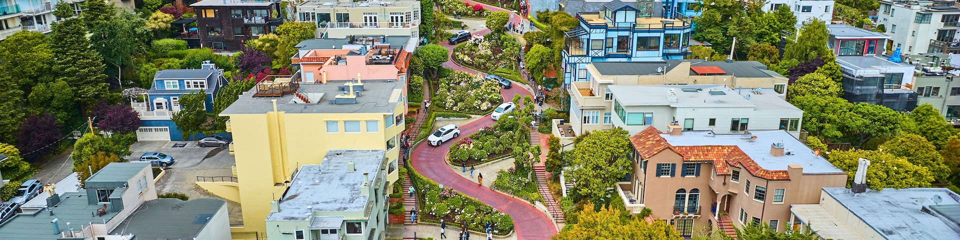 Gorgeous wider aerial of iconic Lombard Street with buildings on either side of red brick road