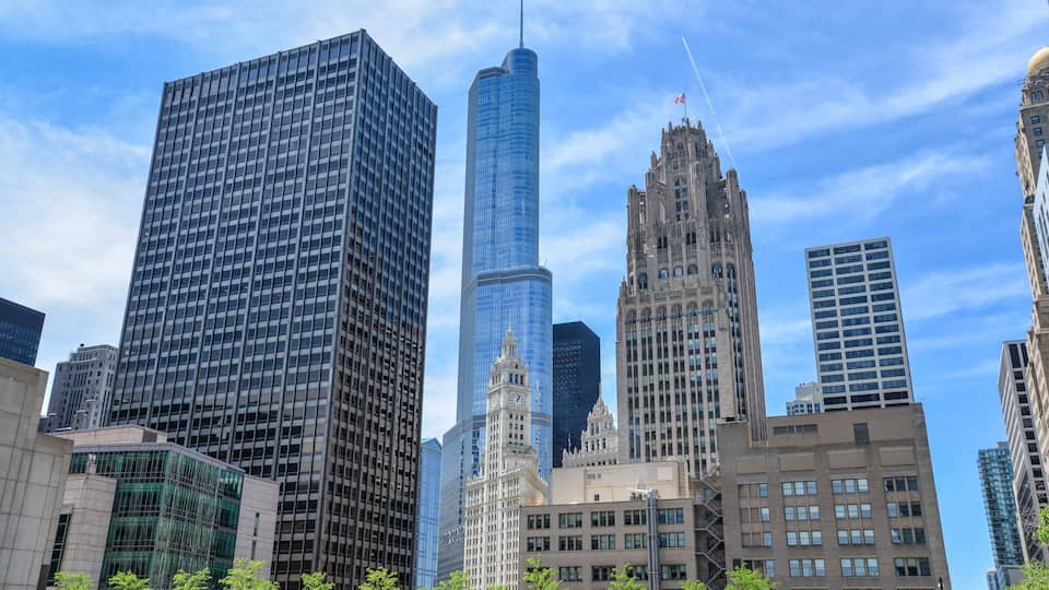 A cityscape with modern skyscrapers, including a distinctive tower with a clock.