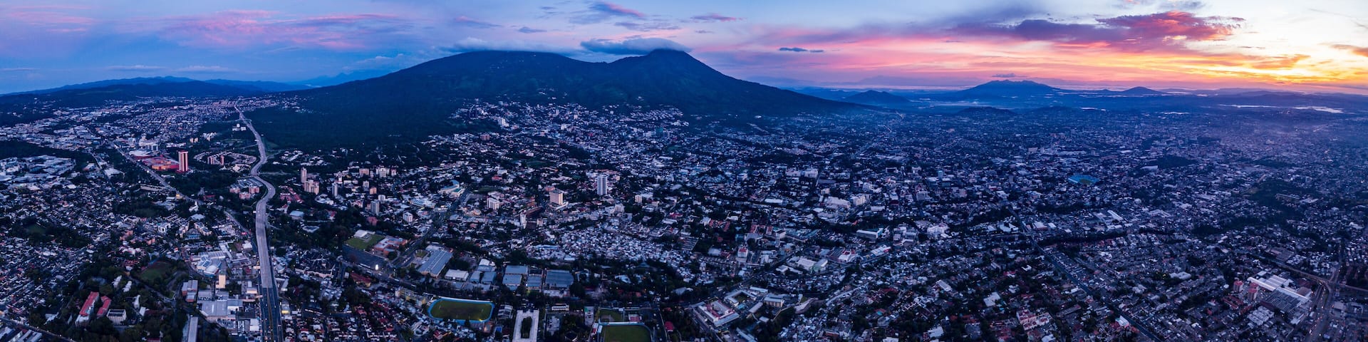 A cityscape with a prominent mountain in the background.