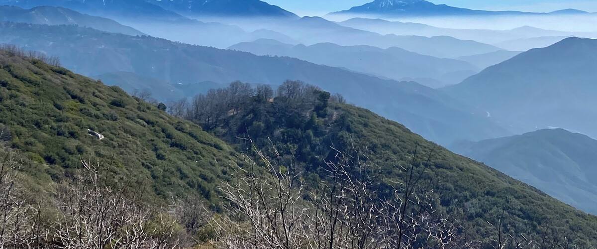 A mountain range with snow-capped peaks and a clear blue sky.