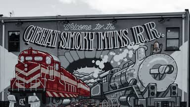 Um mural com um trem vermelho e o texto 'Welcome to the Great Smoky Mountains, N.R.'