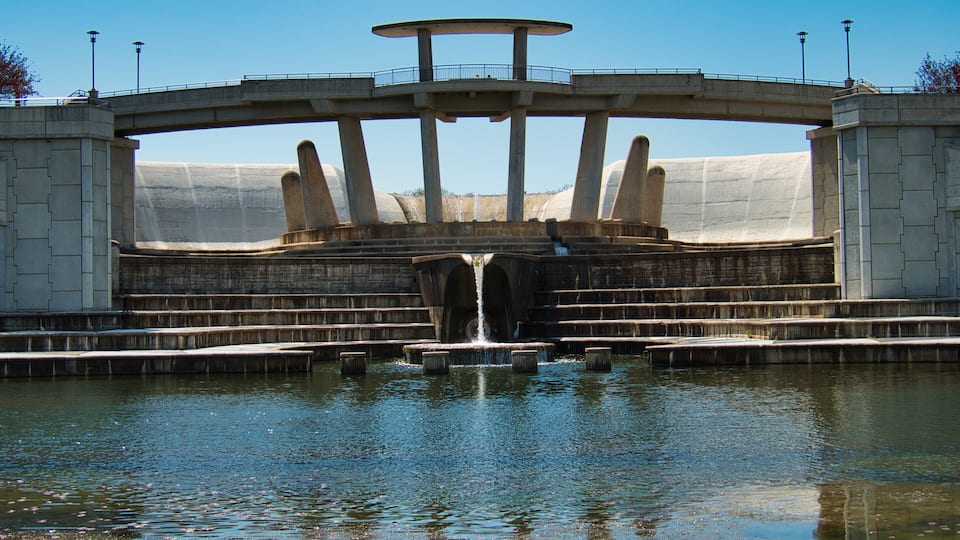 A large dam with multiple water channels and a central tower.
