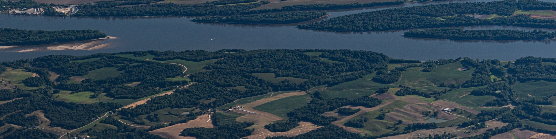 Vista aérea de un río serpenteando por un paisaje con campos, bosques y pequeñas poblaciones.