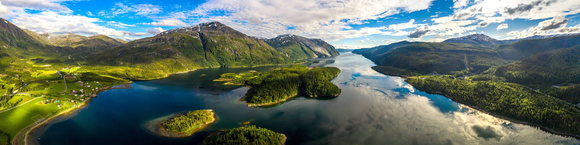 A mountainous landscape with a lake and forested areas.
