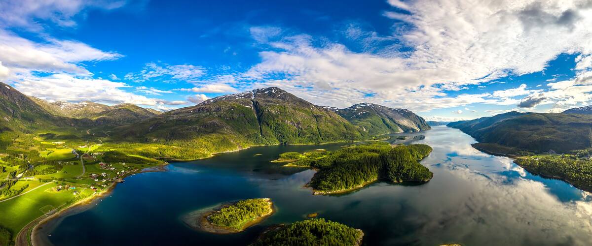 A mountainous landscape with a lake and forested areas.