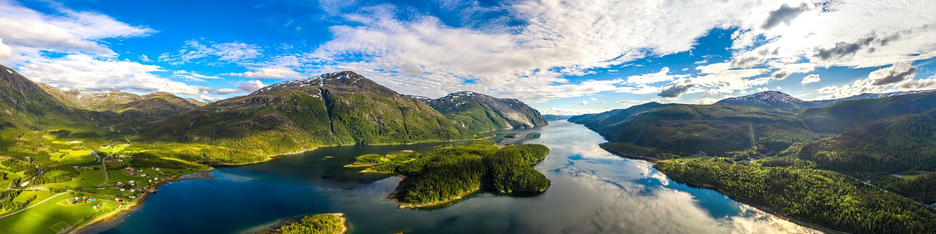 A mountainous landscape with a lake and forested areas.