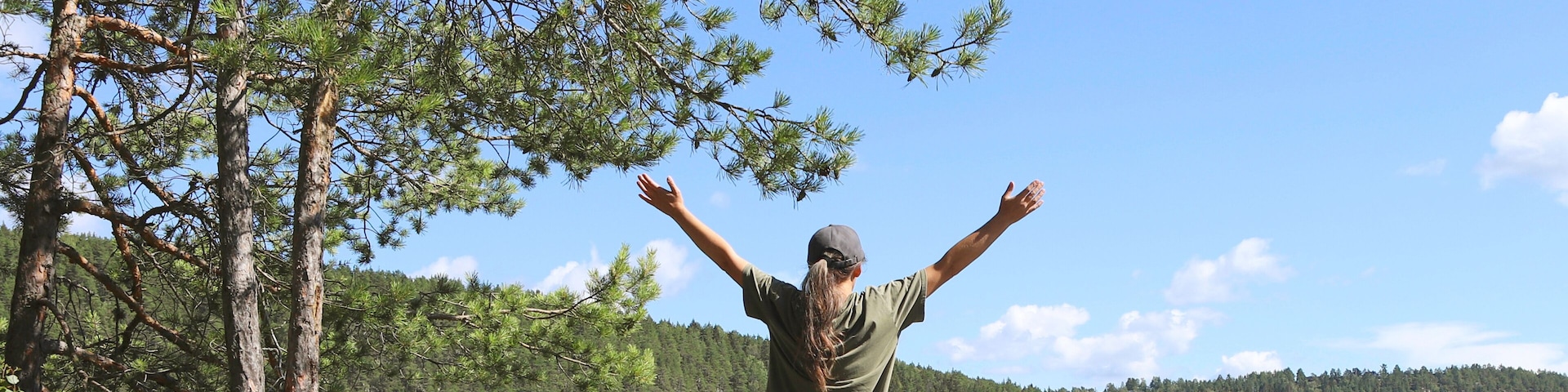 Woman enjoying the view by the lake. Woman hiking in forest near lake in Norway, Oslo, Østensjøvannet lake.