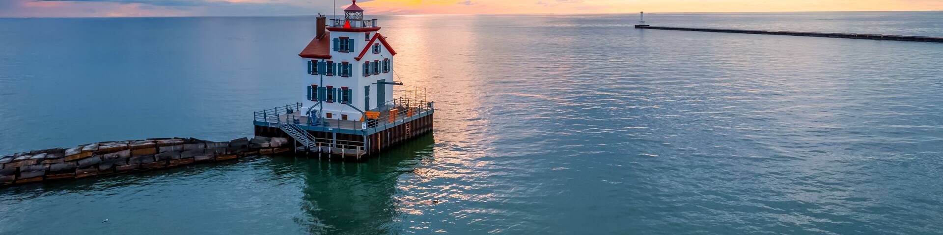 Lorain harbor lighthouse in the middle of lake Erie, under evening light.